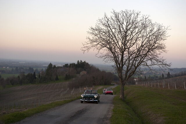 Cars on Tuscan roads at sunset